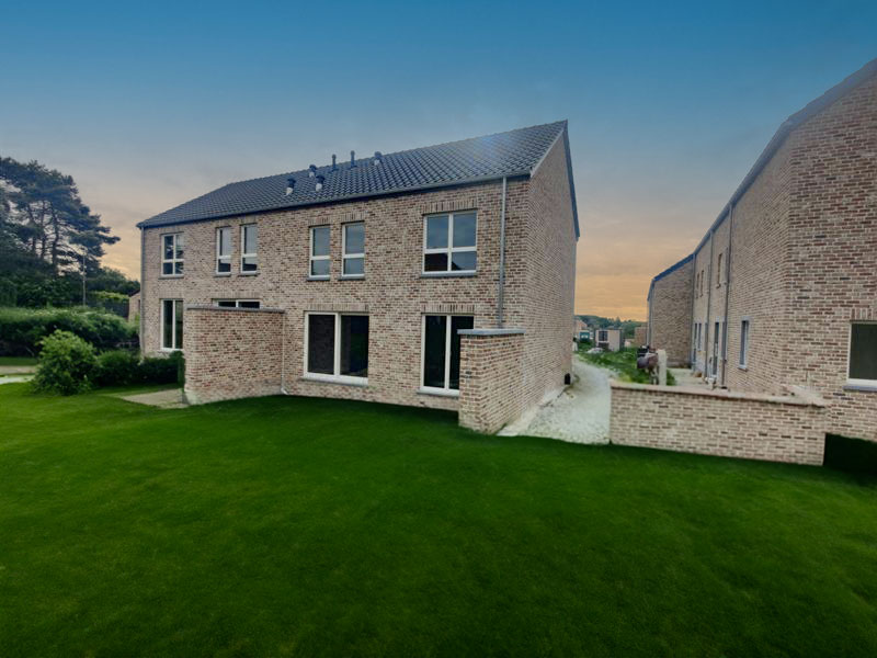 Maisons TopConstruct terminées, vues depuis la pelouse en fin de journée